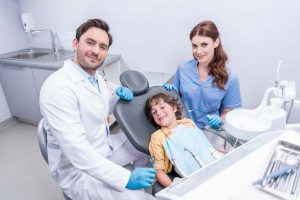 dentists preparing little boy for examining teeth SGKWTC6